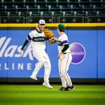Edmonds-Woodways Jonah Brower smiles and high-fives teammate Jens Simonsen after making a catch in the outfield. (Olivia Vanni / The Herald)
