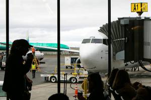 Flyers wait to become the first passengers to depart on a Boeing 737 from Paine Field Airport Thursday, Feb. 17, 2022, in Everett, Washington. (Ryan Berry / The Herald)
