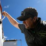 Andrew Albert sets the output on his fertilizer spreader Friday at his farm in Arlington. (Ryan Berry / The Herald)
