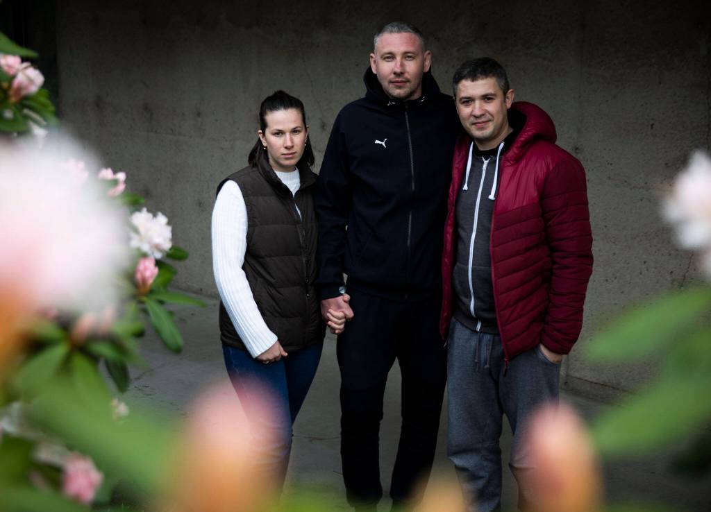 Husband and wife Nataliia Ktitorova, Vitalii Ktitorov and brother-in-law Yosip Lakatosh, right, at the Refugee & Immigrant Services Northwest office on March 24 in Everett. (Olivia Vanni / The Herald)