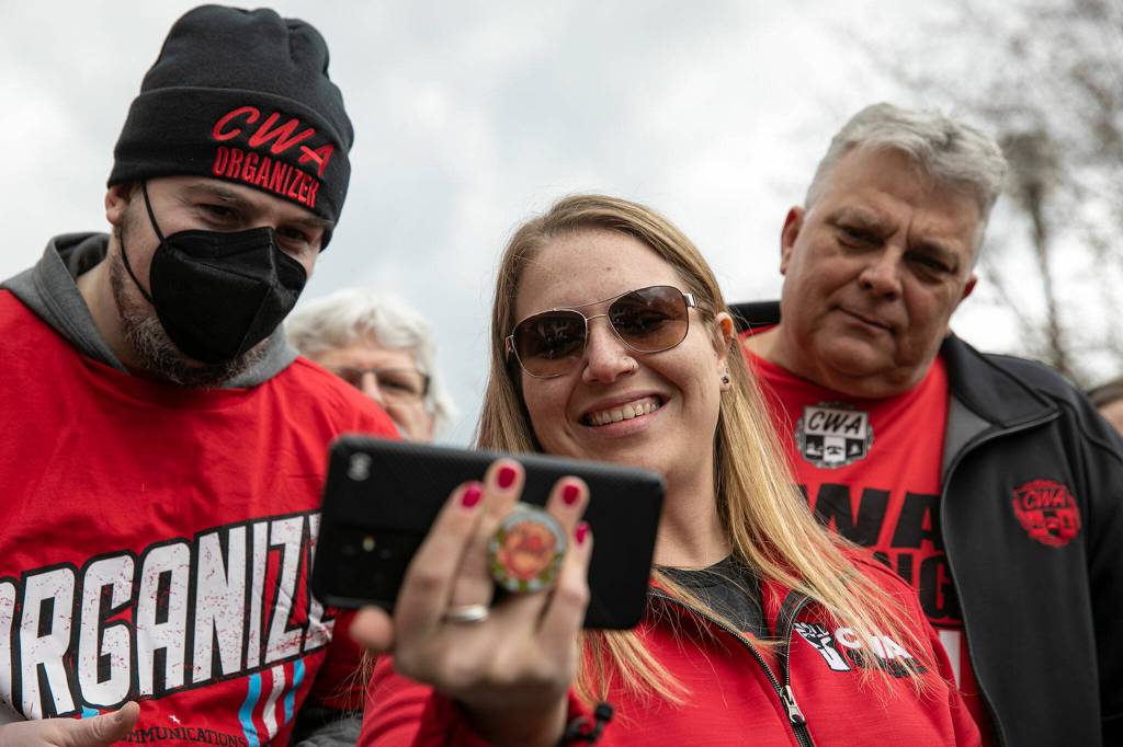From left, Austin Hitch, Carissa Hahn and Darrin Hartman watch a livestream as a union vote comes to a close Friday at a Verizon store in Everett. (Ryan Berry / The Herald)