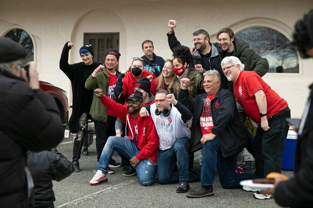 Verizon workers and union supporters take a group photo after an 11-1 vote in favor of unionizing Friday in Everett. (Ryan Berry / The Herald)