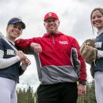 Arlingtons Riley Ryan (left) and Reagan Ryan (right) with their father, Stanwood head softball coach Patrick Ryan. (Kevin Clark / The Herald)