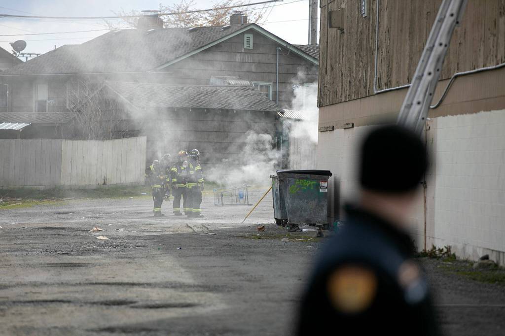 Firefighters work at the far end of the strip mall at 9629 Evergreen Way while responding to a fire Thursday, April 13, 2022, in Everett, Washington. (Ryan Berry / The Herald)