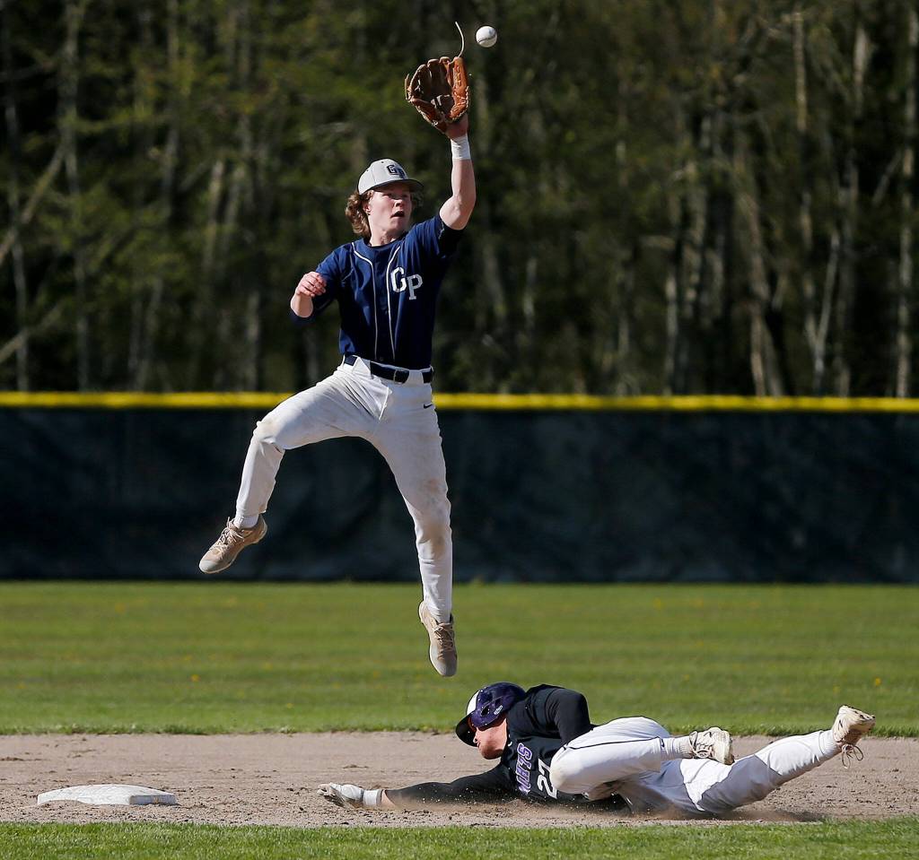 Glacier Peaks Turner Domann grabs a high throw at second base as Kamiaks Cayden Wotipka slides in safely Friday, April 15, 2022, at Kamiak High School in Mukilteo, Washington. (Ryan Berry / The Herald)
