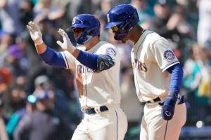 Seattle Mariners' Ty France left, reacts with Julio Rodriguez, right, after France hit a three-run home run to score Rodriguez and Adam Frazier during the fourth inning of a baseball game against the Houston Astros, Sunday, April 17, 2022, in Seattle. (AP Photo/Ted S. Warren)