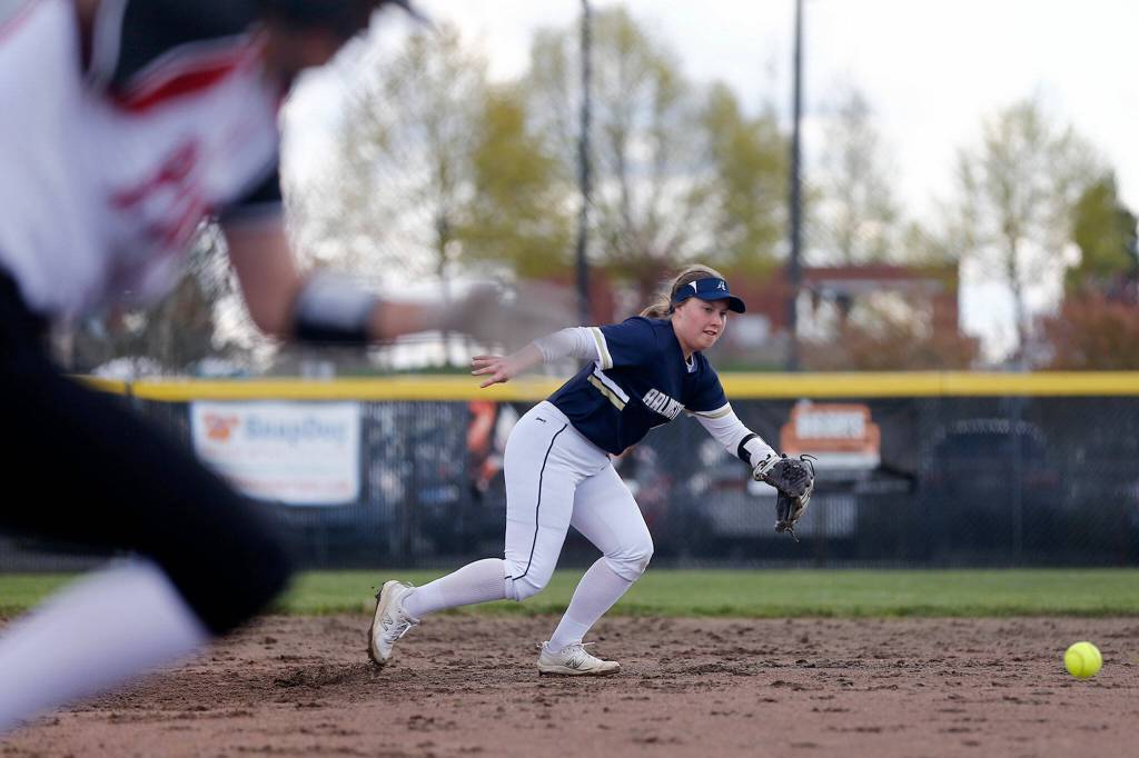 Arlingtons Emmaly Morris heads to her left to try to collect a grounder against Snohomish Tuesday, April 19, 2022, at Snohomish High School in Snohomish, Washington. (Ryan Berry / The Herald)