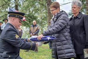 Sgt. Austen Poland, of the Oregon National Guard, presents an American flag to Kylie Tigard, cousin to Tamera 'Tammy' Lee Tigard during a burial at the Valley View Cemetery east of Sutherlin on Monday. The service with full military honors was the final chapter for the U.S. Army specialist whose death remained a mystery for more than four decades.