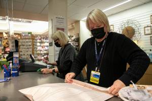 Dianne Easley, left, and Pam Thomas take care of customers at the Providence Regional Medical Center gift shop Thursday, April 21, 2022, in Everett, Washington. (Ryan Berry / The Herald)