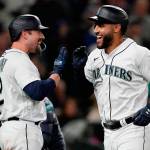 Seattle Mariners' Abraham Toro, right, greets Tom Murphy after Toro hit a two-run home run to score Julio Rodriguez during the seventh inning of the team's baseball game against the Texas Rangers, Tuesday, April 19, 2022, in Seattle. (AP Photo/Ted S. Warren)