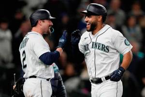 Seattle Mariners' Abraham Toro, right, greets Tom Murphy after Toro hit a two-run home run to score Julio Rodriguez during the seventh inning of the team's baseball game against the Texas Rangers, Tuesday, April 19, 2022, in Seattle. (AP Photo/Ted S. Warren)