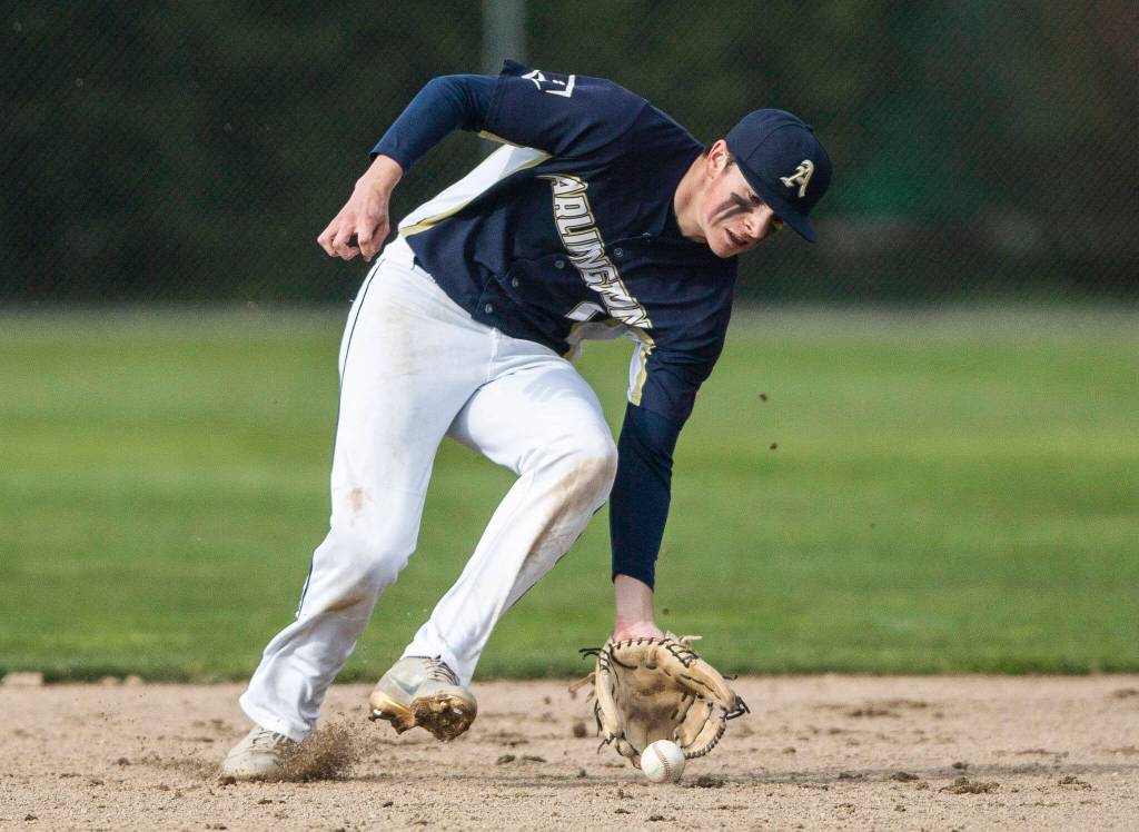 Arlingtons Aiden Green picks up a ground ball during the game against Monroe on Thursday, April 21, 2022 in Arlington, Washington. (Olivia Vanni / The Herald)