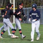 Monroes Parker Mann is congratulated by his teammates after beating Arlingtons Jake Willis to first base to get him out during the game on Thursday, April 21, 2022 in Arlington, Washington. (Olivia Vanni / The Herald)