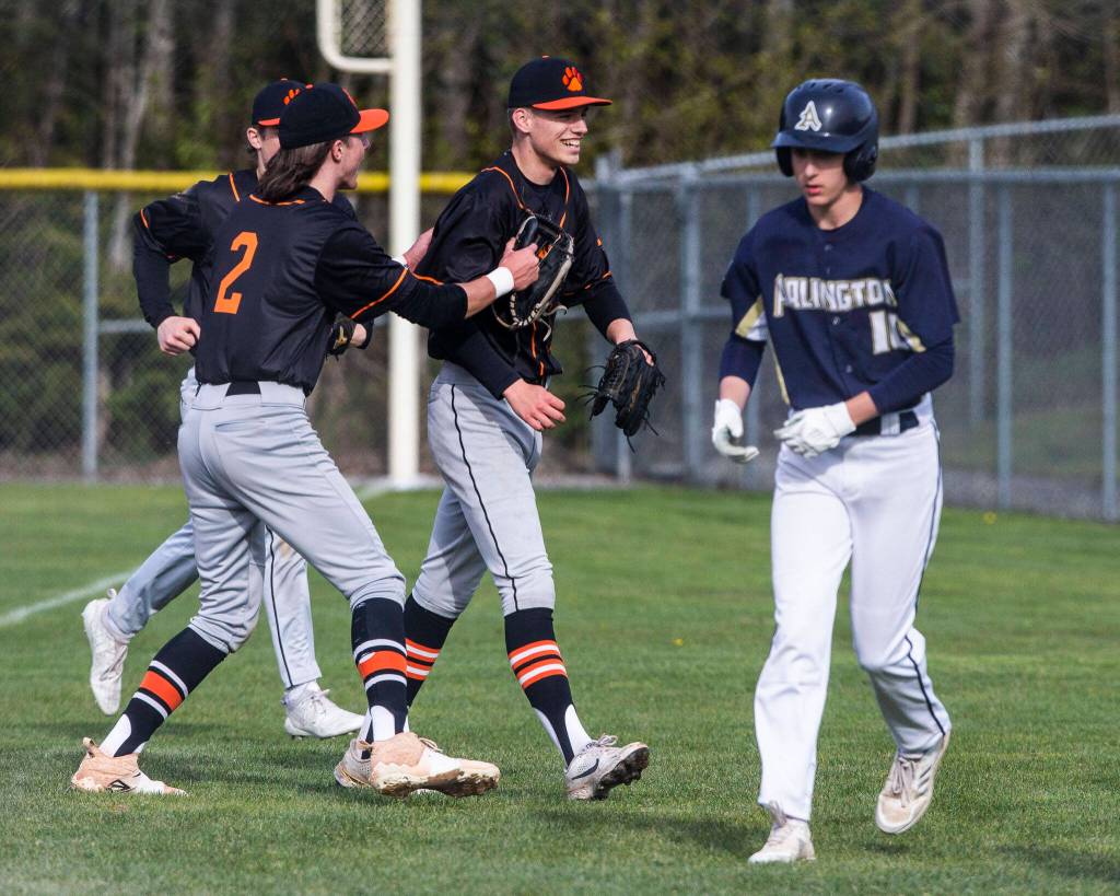 Monroes Parker Mann is congratulated by his teammates after beating Arlingtons Jake Willis to first base to get him out during the game on Thursday, April 21, 2022 in Arlington, Washington. (Olivia Vanni / The Herald)