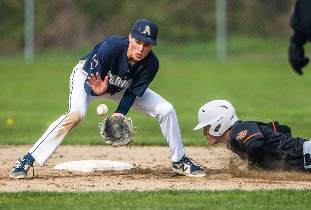 Arlingtons Tyler Rusko catches a ground ball while Monroes Kody Edelbrock slides into second base during the game on Thursday, April 21, 2022 in Arlington, Washington. (Olivia Vanni / The Herald)