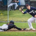 Arlingtons Tyler Mills catches the ball as a Monroe player slides back to first base during the game on Thursday, April 21, 2022 in Arlington, Washington. (Olivia Vanni / The Herald)