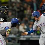 The Rangers Nick Solak (right) is greeted by Adolis Garcia after Solak hit a two-run home run during the fifth inning of a game against the Mariners on Thursday in Seattle. (AP Photo/Ted S. Warren)