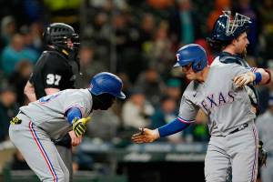 Texas Rangers' Nick Solak, right, is greeted by Adolis Garcia after Solak hit a two-run home run to score Garcia during the fifth inning against the Seattle Mariners in a baseball game Thursday, April 21, 2022, in Seattle. (AP Photo/Ted S. Warren)