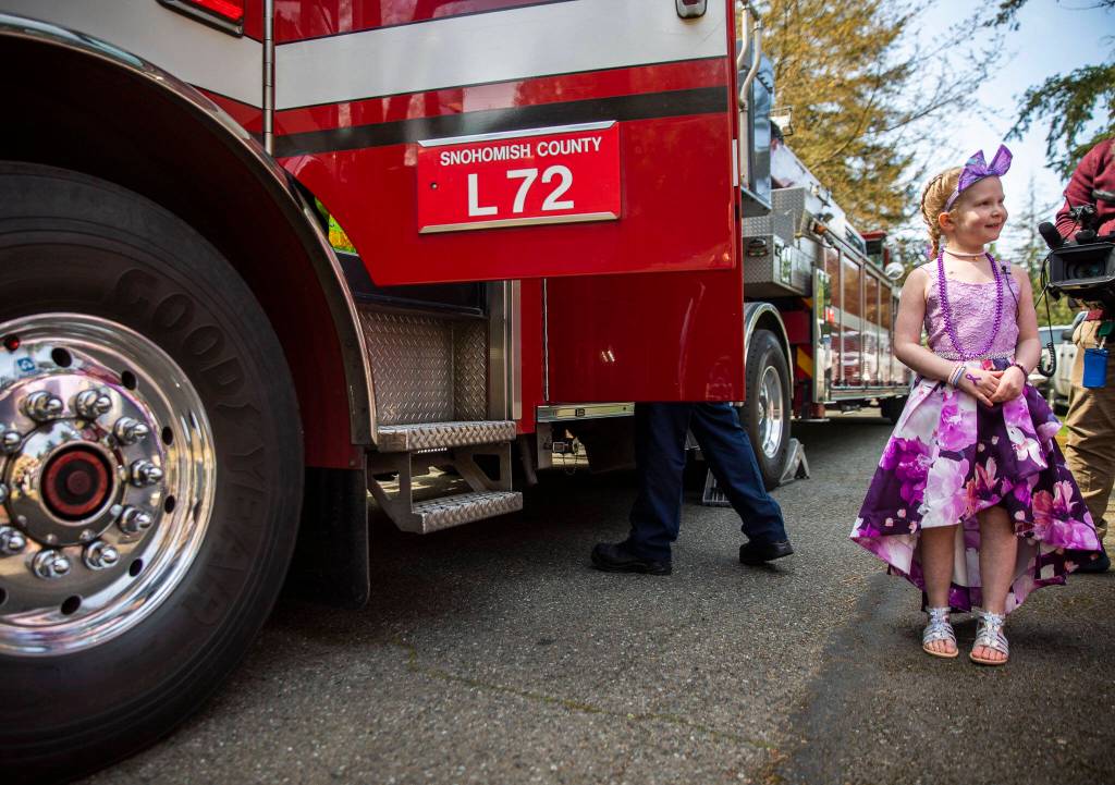 Peyton Vandanacker waits to get into a firetruck to celebrate the end of her chemotherapy treatment on Saturday, April 23, 2022 in Bothell, Washington. (Olivia Vanni / The Herald)