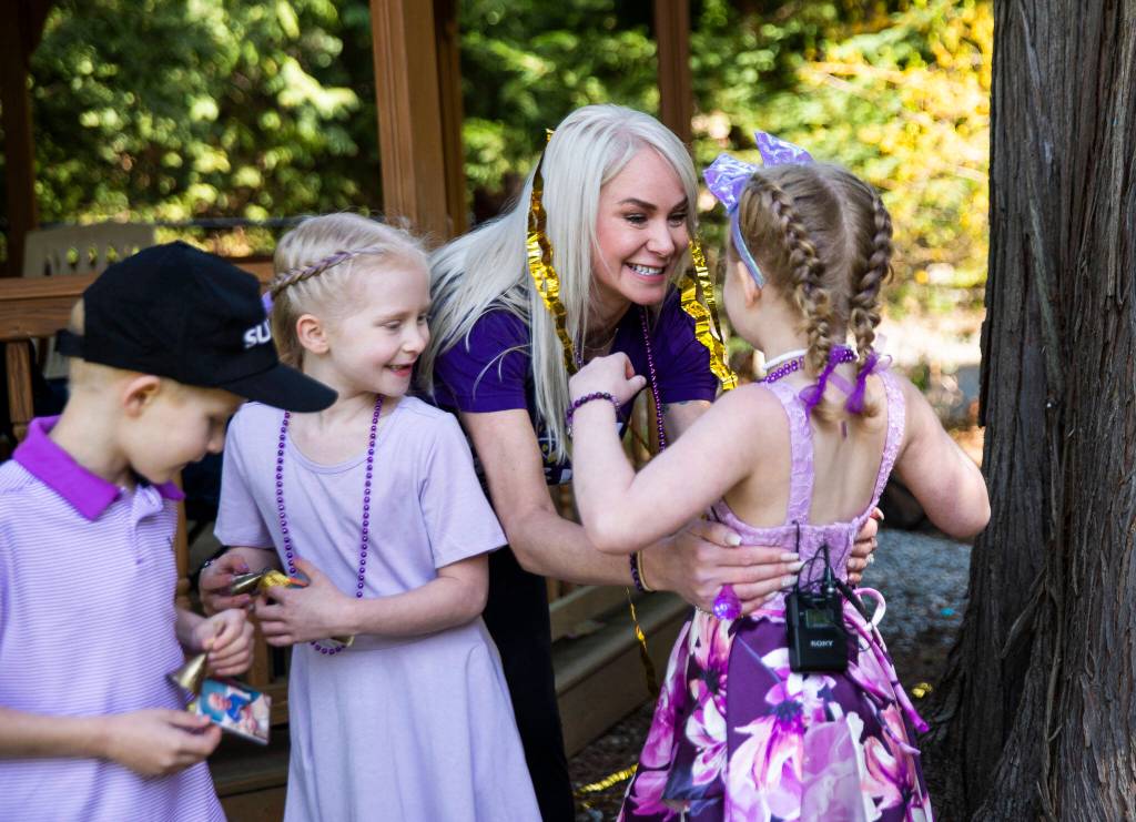 Kelli Vandanacker hugs her daughter and whispers, you did it sweetie, after Peyton rings her end of chemotherapy bell on Saturday, April 23, 2022 in Bothell, Washington. (Olivia Vanni / The Herald)