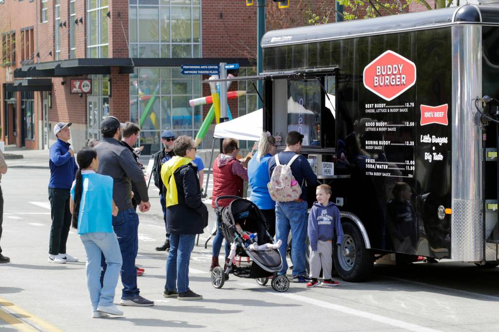 Customers gather at the Buddy Burger food trailer Saturday morning in Everett. (Kevin Clark / The Herald)
