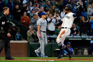Seattle Mariners' Julio Rodriguez, right, scores off a triple by Jarred Kelenic during the fourth inning of a baseball game against the Kansas City Royals, Friday, April 22, 2022, in Seattle. (AP Photo/Jason Redmond)