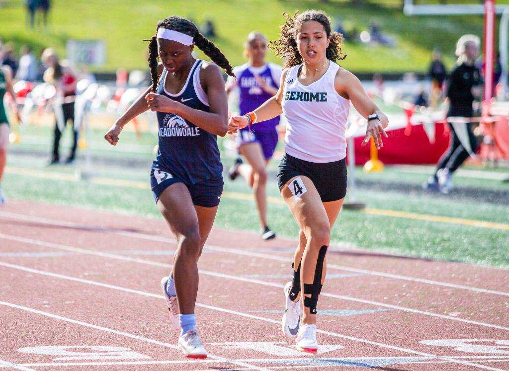 Meadowdale junior Tresley Love leans across the finish line to beat Sehomes Jayda Darroch in the girls 400 meters. (Olivia Vanni / The Herald)