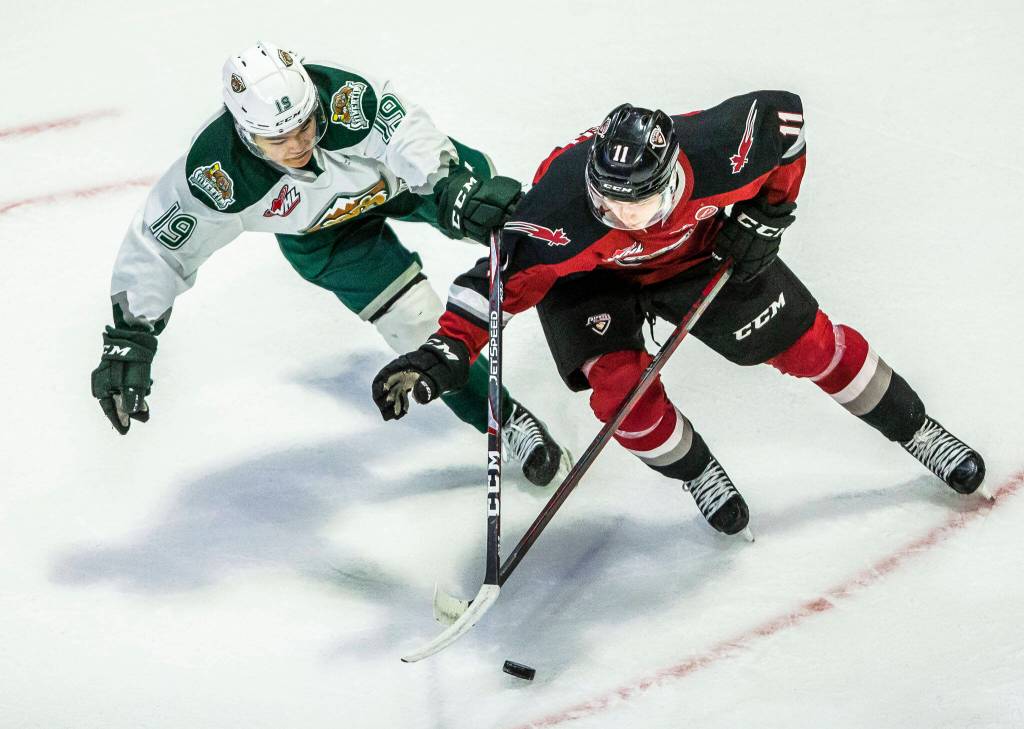 Silvertips Matthew Ng and Giants Fabian Lysell fight for the puck during the playoff match up against the Vancouver Giants on Saturday, April 23, 2022 in Everett, Washington. (Olivia Vanni / The Herald)