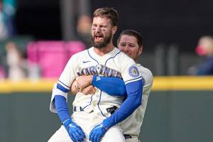 Seattle Mariners' Jesse Winker, front right, is lifted by Ty France as he celebrates a win over Kansas City Royals in 12 innings of a baseball game, Sunday, April 24, 2022, in Seattle. (AP Photo/John Froschauer)