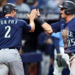 Seattle Mariners' Dylan Moore (25) celebrates with Tom Murphy as both score against the Tampa Bay Rays during the fourth inning of a baseball game Tuesday, April 26, 2022, in St. Petersburg, Fla. (AP Photo/Mike Carlson)