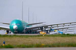 A line of Boeing 777X jets, with their unique folding wingtips pulled up, are parked nose to tail on an unused runway at Paine Field, near Boeing's massive production facility, Friday, April 23, 2021, in Everett, Wash. (AP Photo/Elaine Thompson)