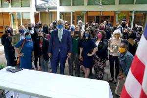 Washington Gov. Jay Inslee, center, reacts after he signed a bill into law in Tukwila, Wash., Tuesday, May 4, 2021, that levies a new capital gains tax on high profit stocks, bonds and other assets for some residents of Washington state. (AP Photo/Ted S. Warren)