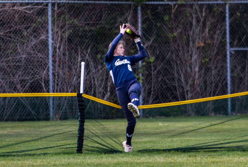 Glacier Peaks Leyla Carpenter makes a catch over the back barrier during the game against Jackson on Thursday, April 28, 2022 in Everett, Washington. (Olivia Vanni / The Herald)
