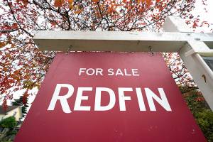 FILE - A Redfin "for sale" sign stands in front of a house on Oct. 28, 2020, in Seattle. The National Fair Housing Alliance on Friday, April 29, 2022, announced a settlement agreement to resolve a lawsuit against Redfin that will expand housing opportunities for consumers in communities of color in major cities. Under the agreement, Seattle-based Redfin will change its minimum housing price policy, alter other practices, and pay $4 million. (AP Photo/Elaine Thompson, File)