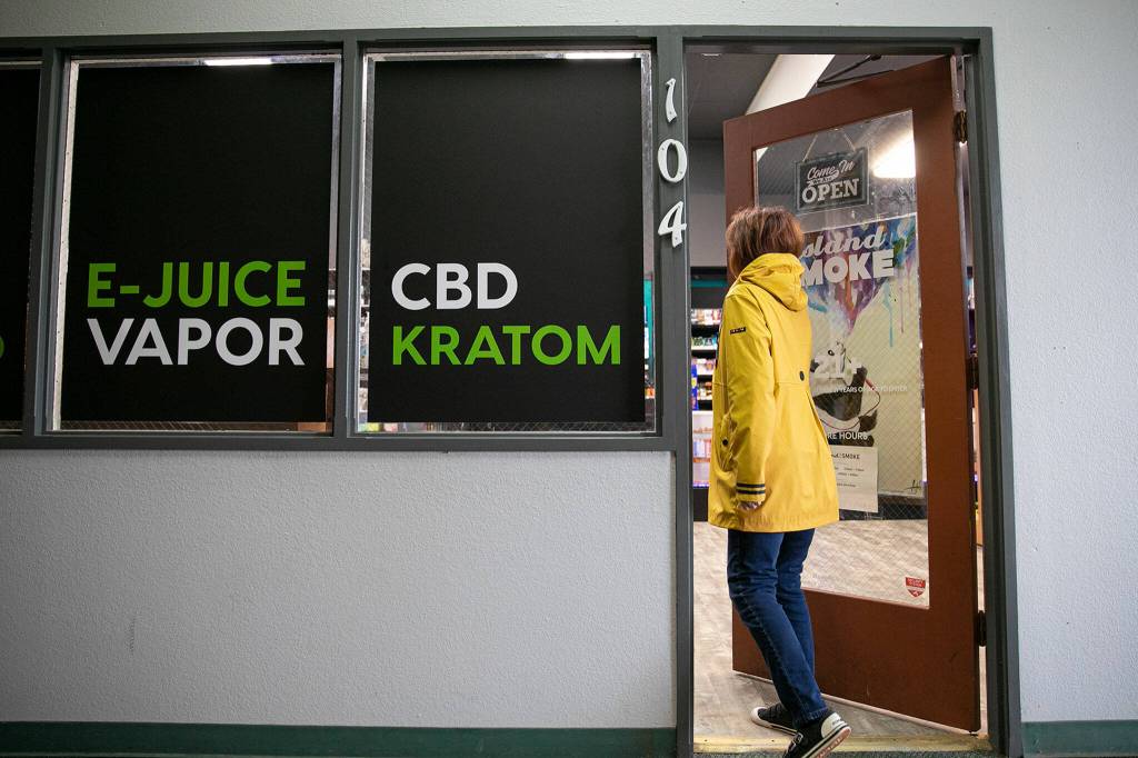 A customer enters Island Smoke at Kens Korner shopping plaza in Clinton on Whidbey Island. (Ryan Berry / The Herald)
