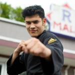 Emanuel Rodriguez Ruiz, 23, strikes a pose in front of his studio, Rodriguez Taekwondo Martial Arts, on Thursday at an old strip mall on Main Street in Sultan. Rodriguez Ruiz, who grew up in Monroe and started his studio at the beginning of May, is one of Sultans newest business owners. (Ryan Berry / The Herald)