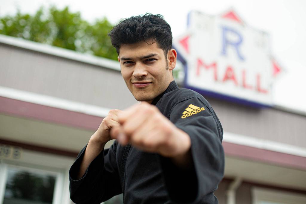 Emanuel Rodriguez Ruiz, 23, strikes a pose in front of his studio, Rodriguez Taekwondo Martial Arts, on Thursday at an old strip mall on Main Street in Sultan. Rodriguez Ruiz, who grew up in Monroe and started his studio at the beginning of May, is one of Sultans newest business owners. (Ryan Berry / The Herald)