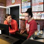 Co-owner of J.B. Fitness Candice Blair (left) talks with employee Kathryn Agnew at the front desk of the recently relocated business Thursday in Sultan. (Ryan Berry / The Herald)