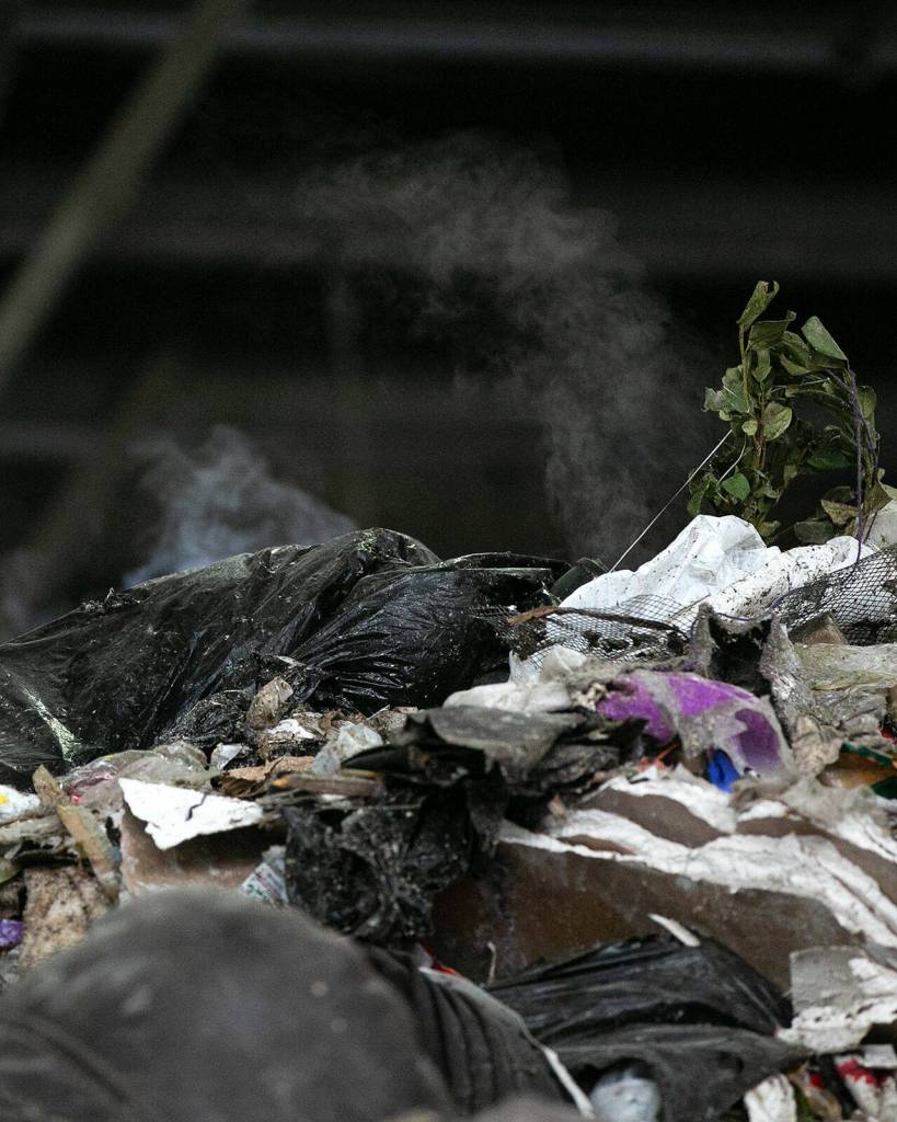 Steam rises from the top of a gigantic pile of garbage Friday, April 29, 2022, at the Airport Road Recycling and Transfer Station in Everett, Washington. The facility is on 24/7 fire watch due to the increased chances of the enormous garbage pile spontaneously combusting. (Ryan Berry / The Herald)
