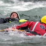 Firefighters perform a rescue drill during the Snohomish Regional Fire & Rescues annual Water Rescue Academy in the Skykomish River on Thursday in Index. (Kevin Clark / The Herald)