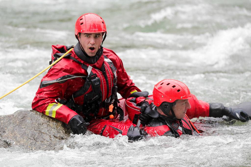 A firefighter calls to shore during the Snohomish Regional Fire Rescues annual Water Rescue Academy in the Skykomish River on Thursday in Index. (Kevin Clark / The Herald)