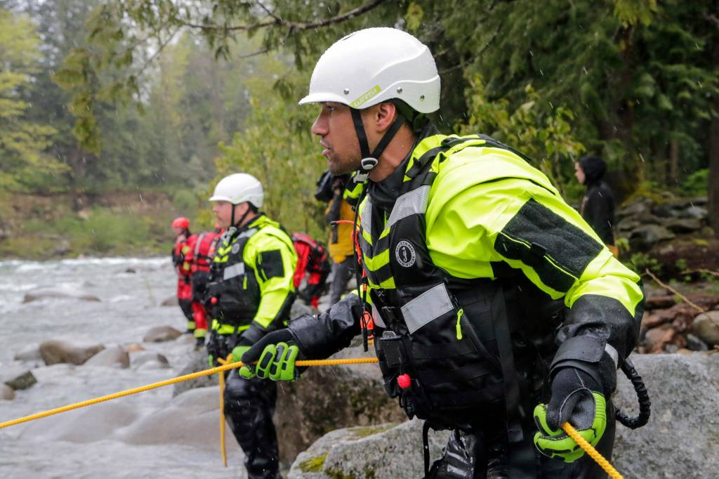 A firefighter anchors the line during a rescue drill in the Skykomish River on Thursday in Index. (Kevin Clark / The Herald)