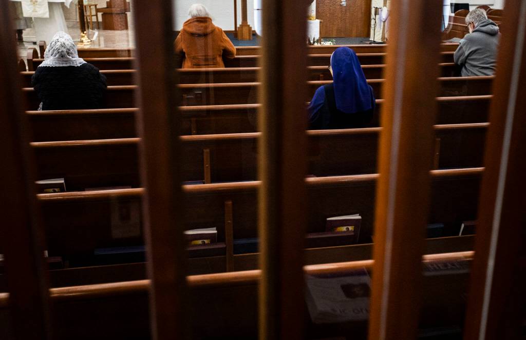 Parishioners pray during morning mass at Immaculate Conception Church on Wednesday in Everett. Declining numbers prompted the Archdiocese of Seattle to decree it merge with Our Lady of Perpetual Help. (Olivia Vanni / The Herald)