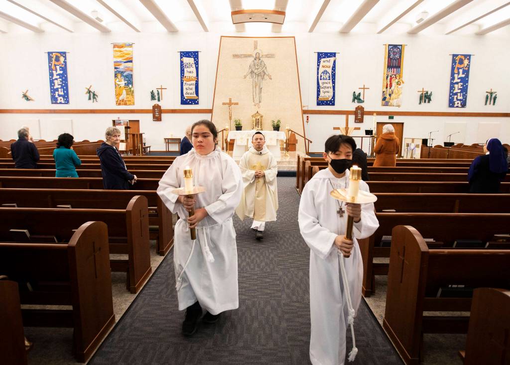 Father Tuan Nguyen walks down the aisle at the end of morning mass at Immaculate Conception Church on Wednesday in Everett. (Olivia Vanni / The Herald)