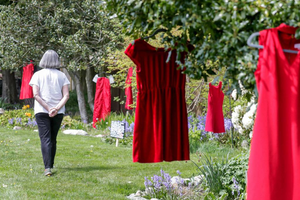 Diana Nielsen browses The Red Dress Project at Edmonds Lutheran Church in Edmonds. (Kevin Clark / The Herald)