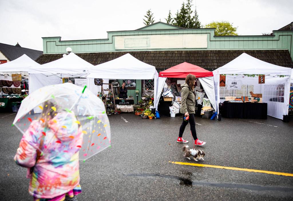 People wander past vendors at the Snohomish Farmers Market on Thursday. (Olivia Vanni / The Herald)