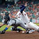Mariners catcher Luis Torrens (left) reaches for the ball as the Astros Alex Bregman scores during the sixth inning of a game Wednesday in Houston. (AP Photo/David J. Phillip)