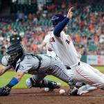Seattle Mariners catcher Luis Torrens, left, reaches for the ball as Houston Astros' Alex Bregman scores during the sixth inning of a baseball game Wednesday, May 4, 2022, in Houston. (AP Photo/David J. Phillip)