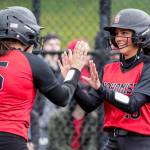 Snohomish's Alli Wilson, left, and welcomes teammate Emma Hansen to the plate, scoring a run against Cascade High School Thursday afternoon at Phil Johnson Ballfields in Everett, Washington on May 5, 2022. The Panthers won 9-3.  (Kevin Clark / The Herald)