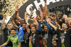 United States' Seattle Sounders midfielder Nicolas Lodeiro holds the trophy alongside teammates after defeating Mexico's Pumas to win the CONCACAF Champions League soccer final Wednesday, May 4, 2022, in Seattle. (AP Photo/Ted S. Warren)